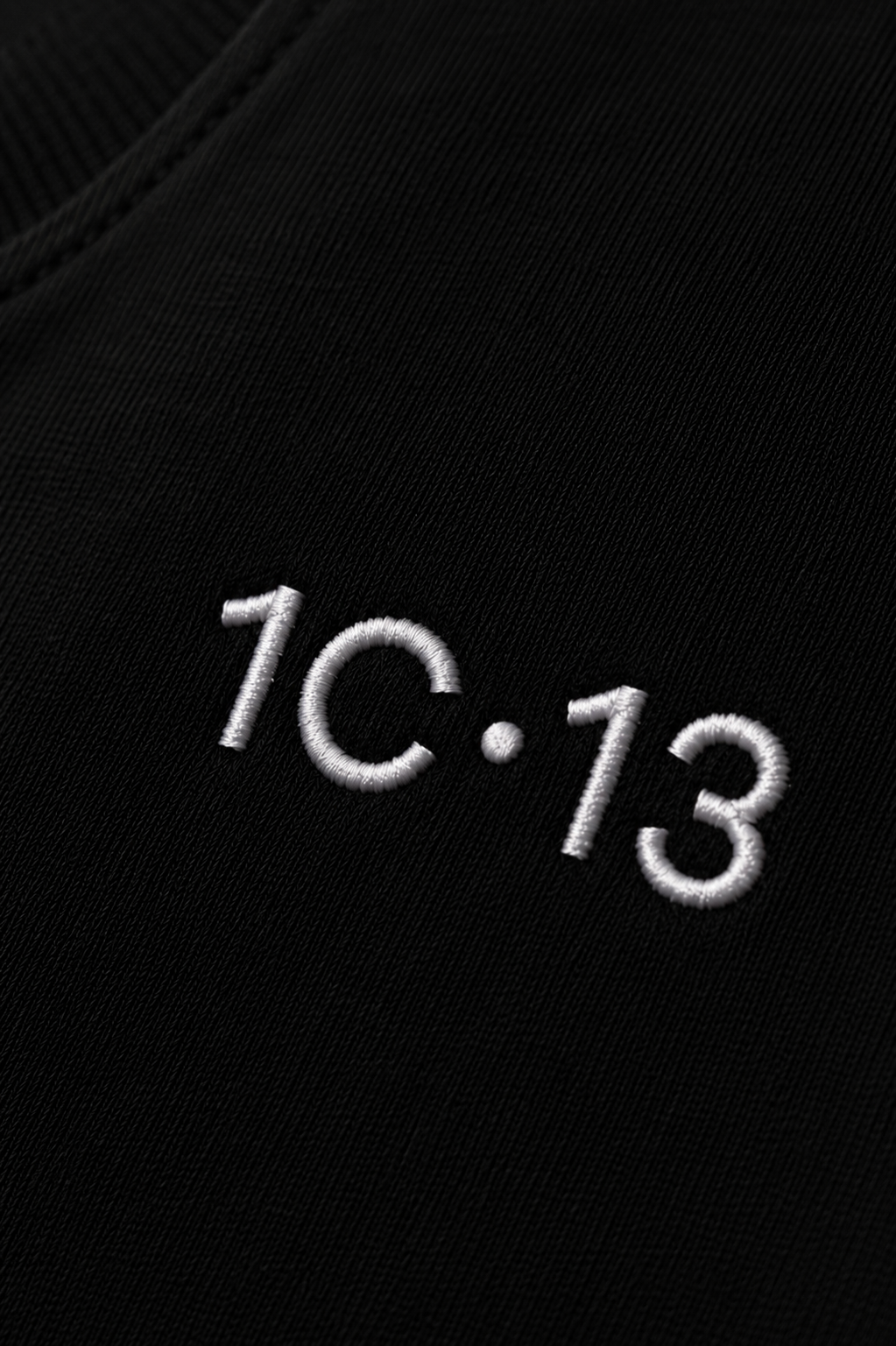 1C·13 embroidered logo detail on black tee fabric