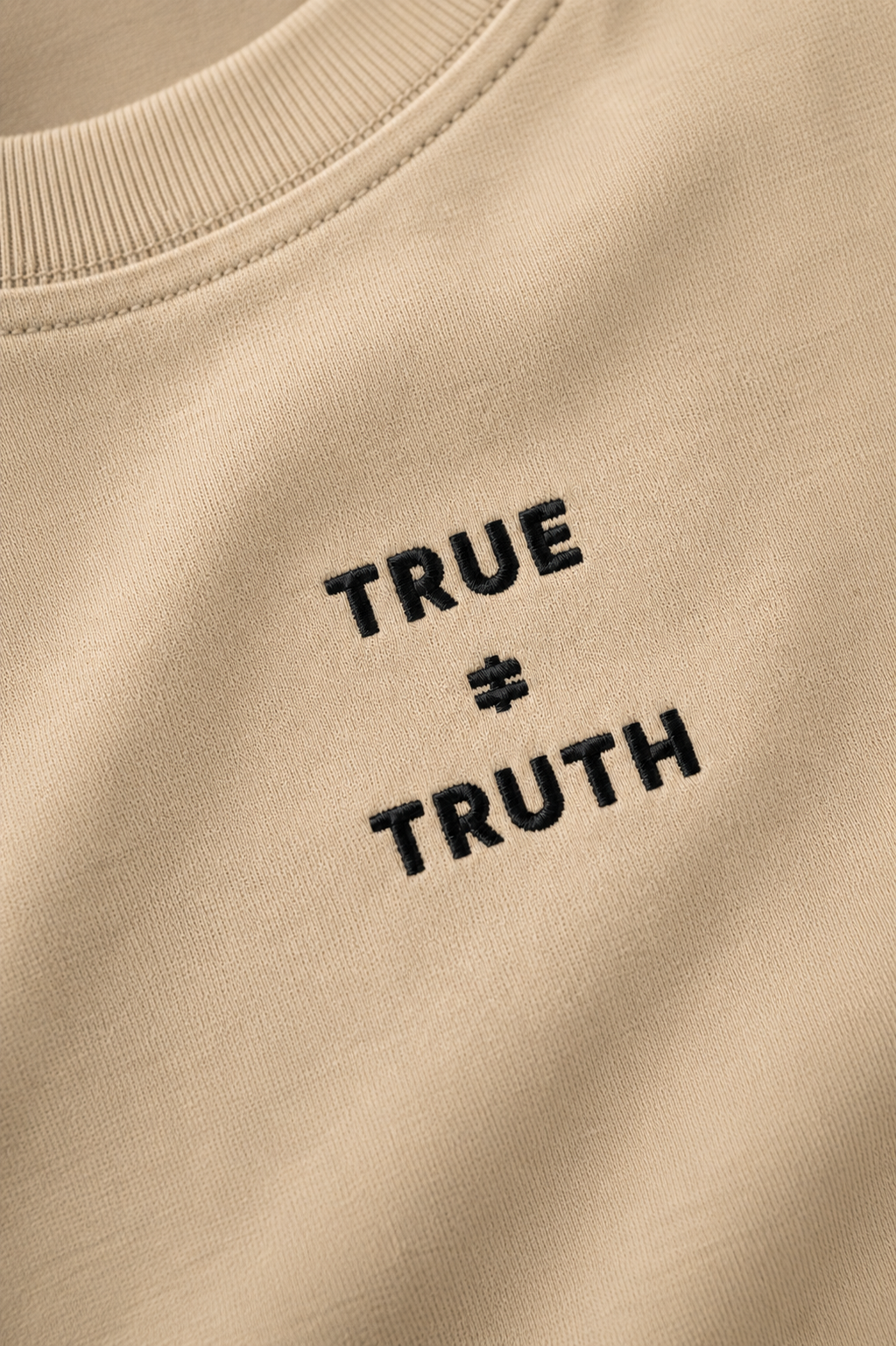 TRUE + TRUTH embroidered logo detail on beige tee