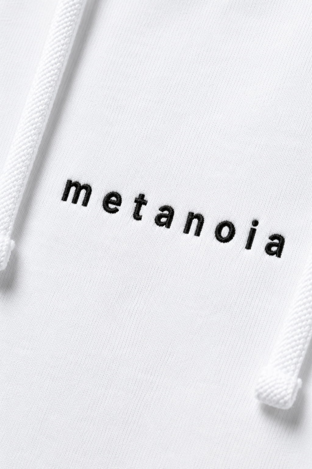 METANOIA embroidered logo detail on white hoodie