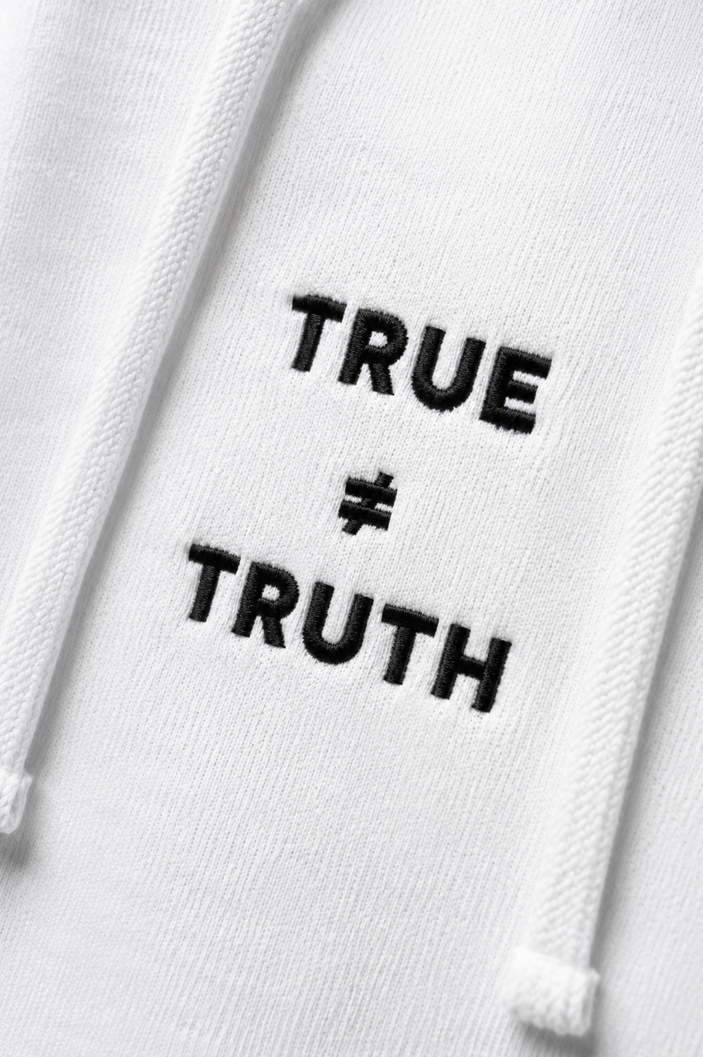 TRUE + TRUTH embroidered logo detail on white hoodie